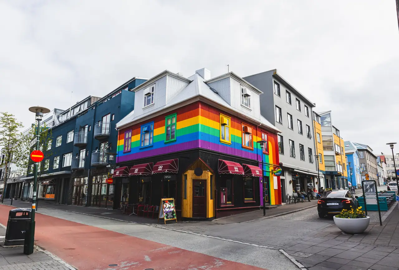 A building painted in rainbow colours on a street corner in Reykjavík.